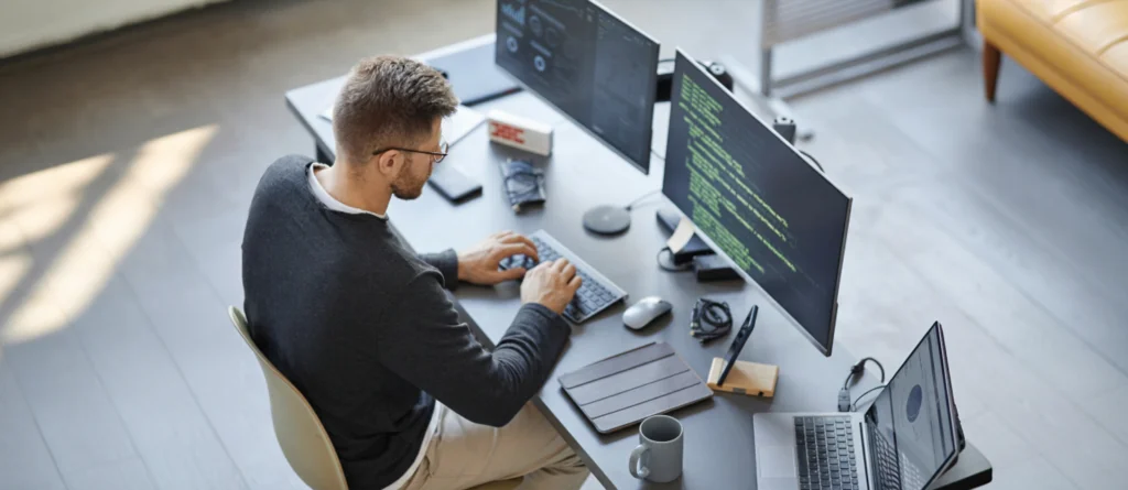 homem branco no escritorio codando no computador